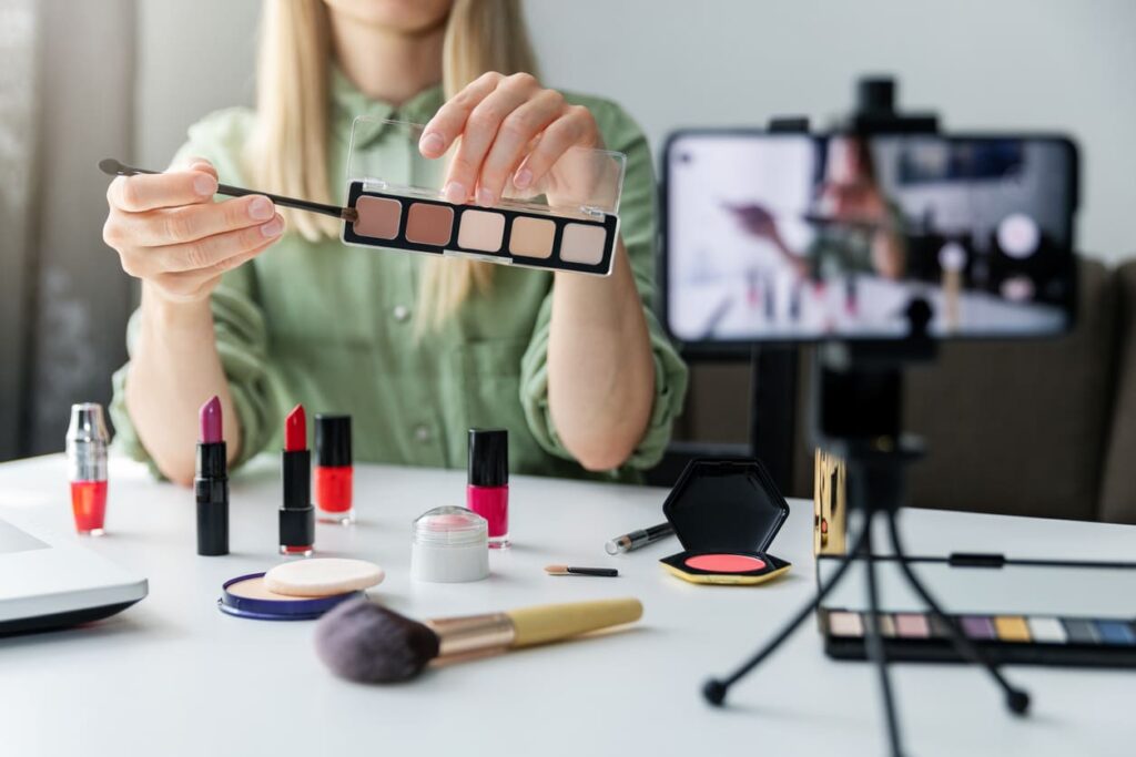 Beauty influencer si filma con smartphone mentre si trucca