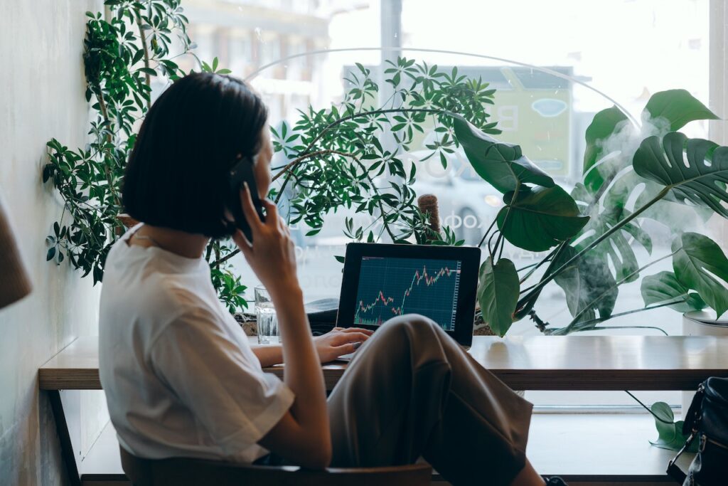 Ragazza al telefono esamina un computer con dei report