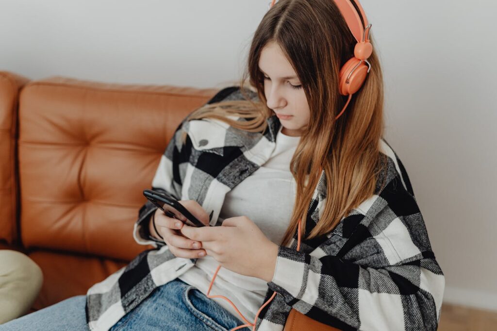 ragazza con camicia a quadri che ascolta la musica sul divano