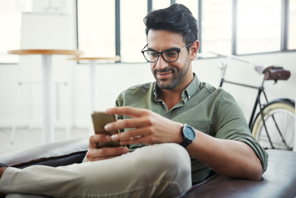 ragazzo sul divano che guarda il cellulare