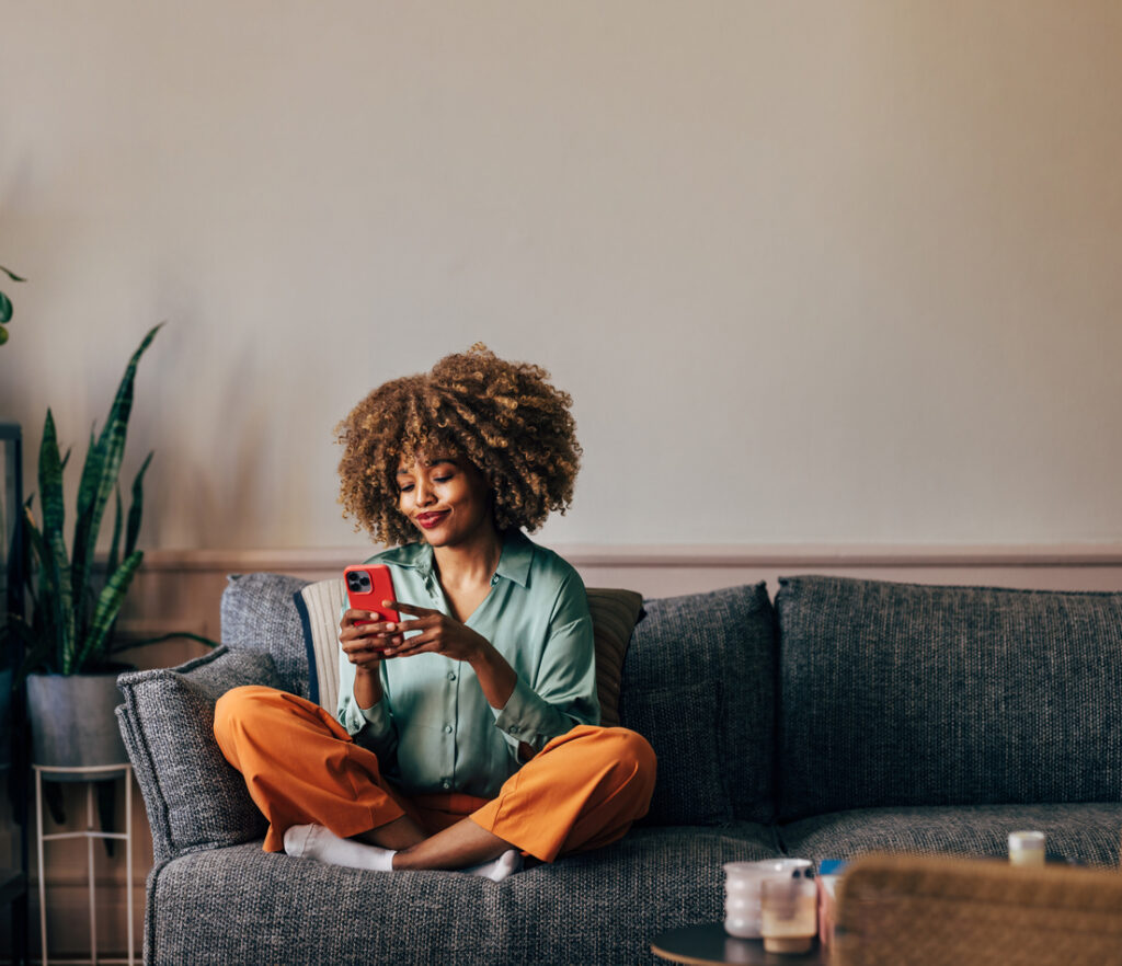 ragazza sul divano che guarda il cellulare